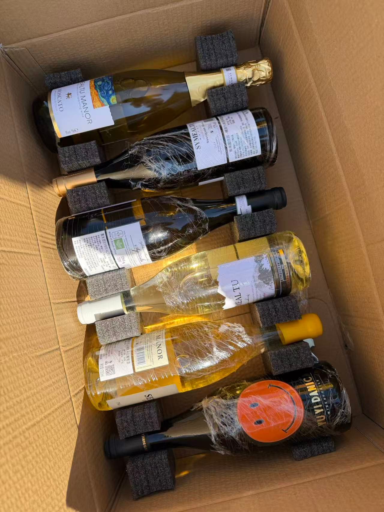 Wrapped bottles of wine in a cardboard box, ready to be chilled at the restaurant for my birthday