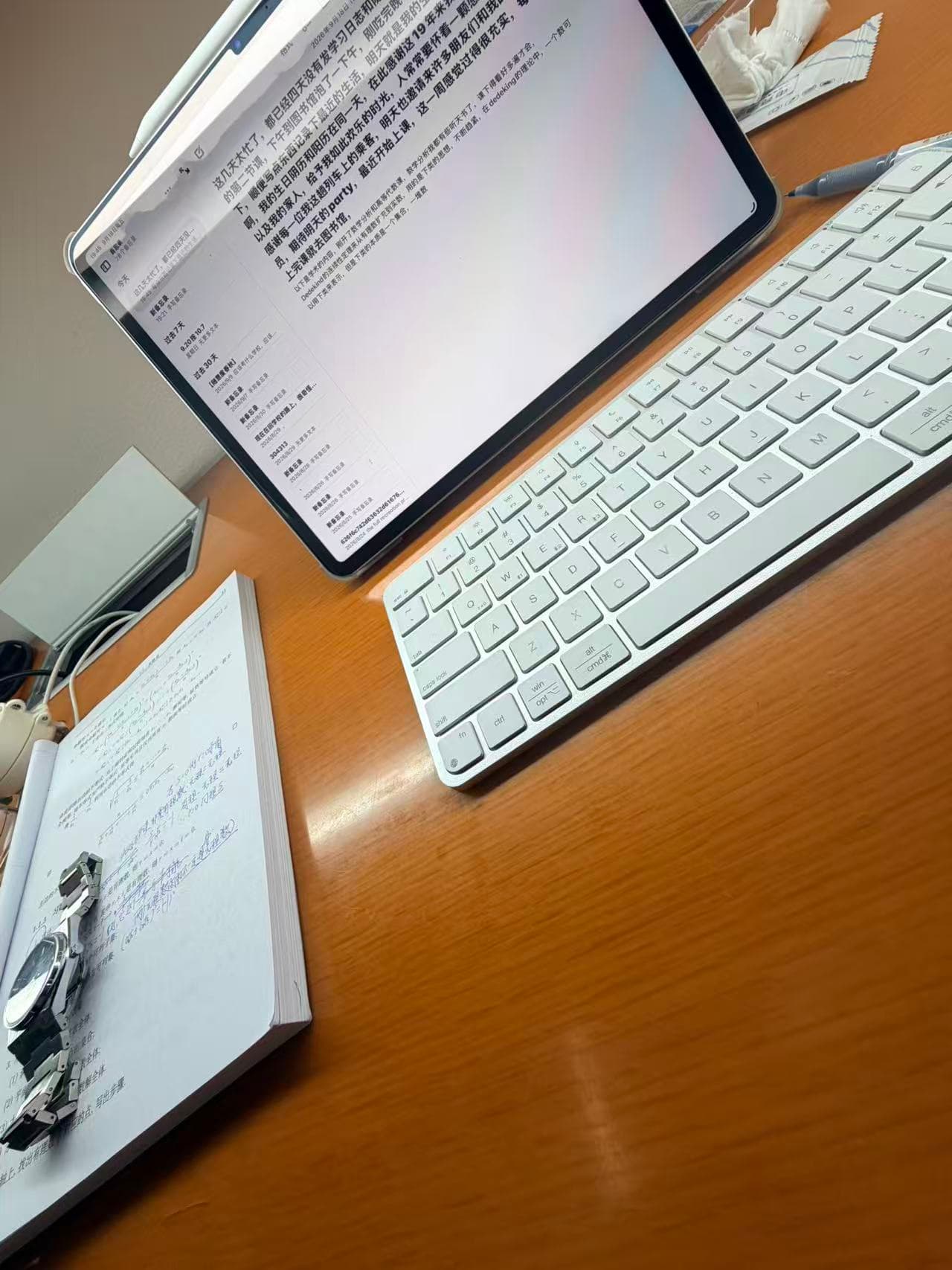 A tablet, mathematical analysis notes, and a watch on a library desk