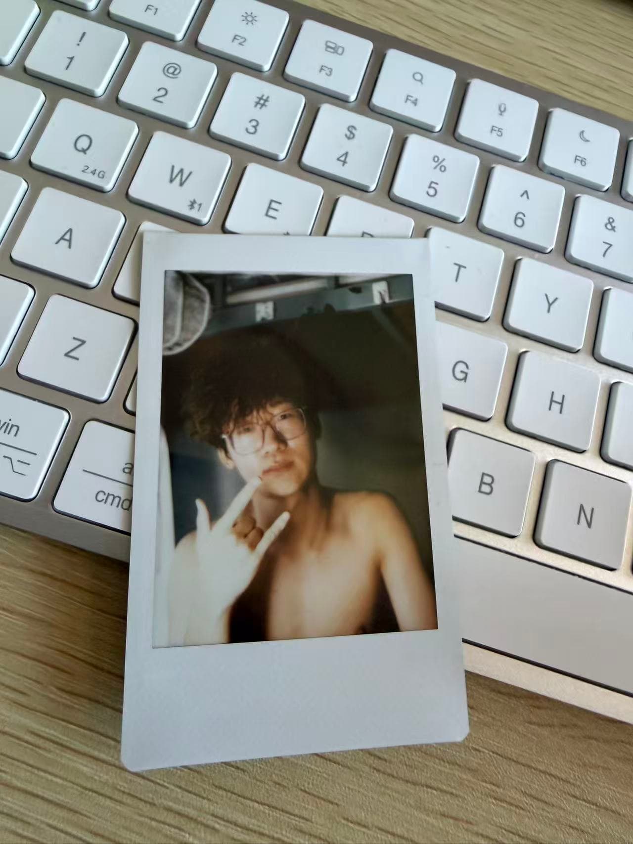 A slightly blurred instant portrait resting on a white keyboard