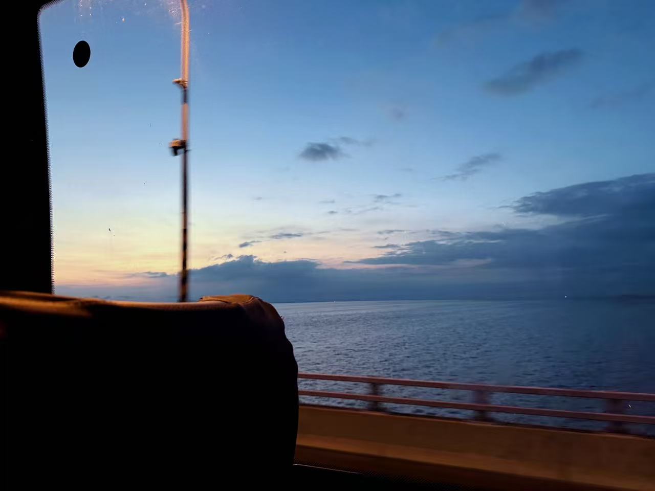 The sea and evening sky seen through the window on the journey home