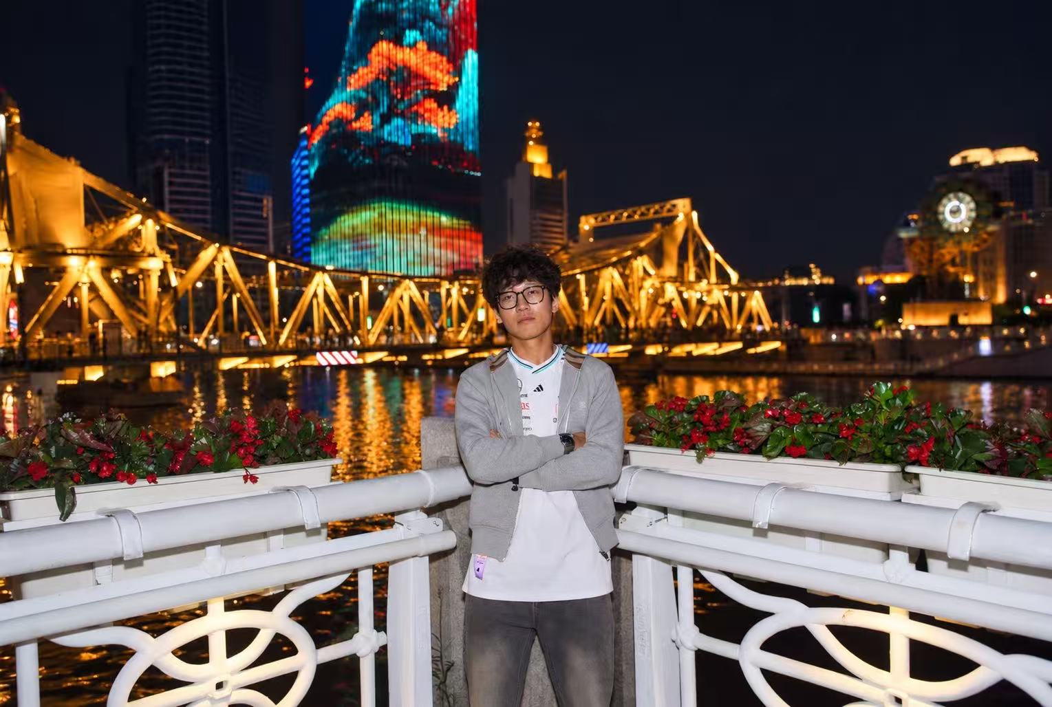 Wearing my new clothes beside the Haihe River with the illuminated Jiefang Bridge behind me