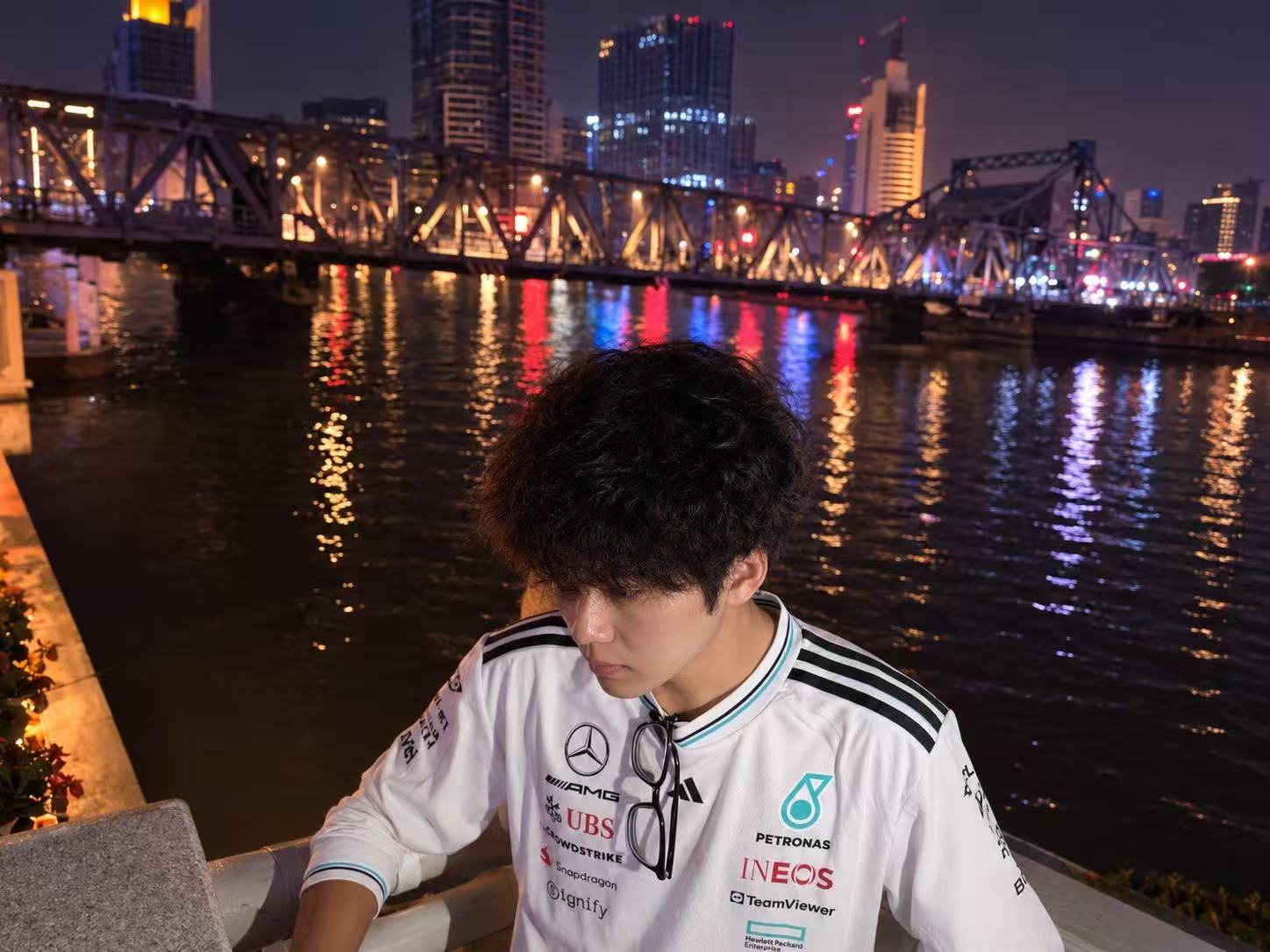 Sitting beside the Haihe River as the bridge and city lights reflect across the water