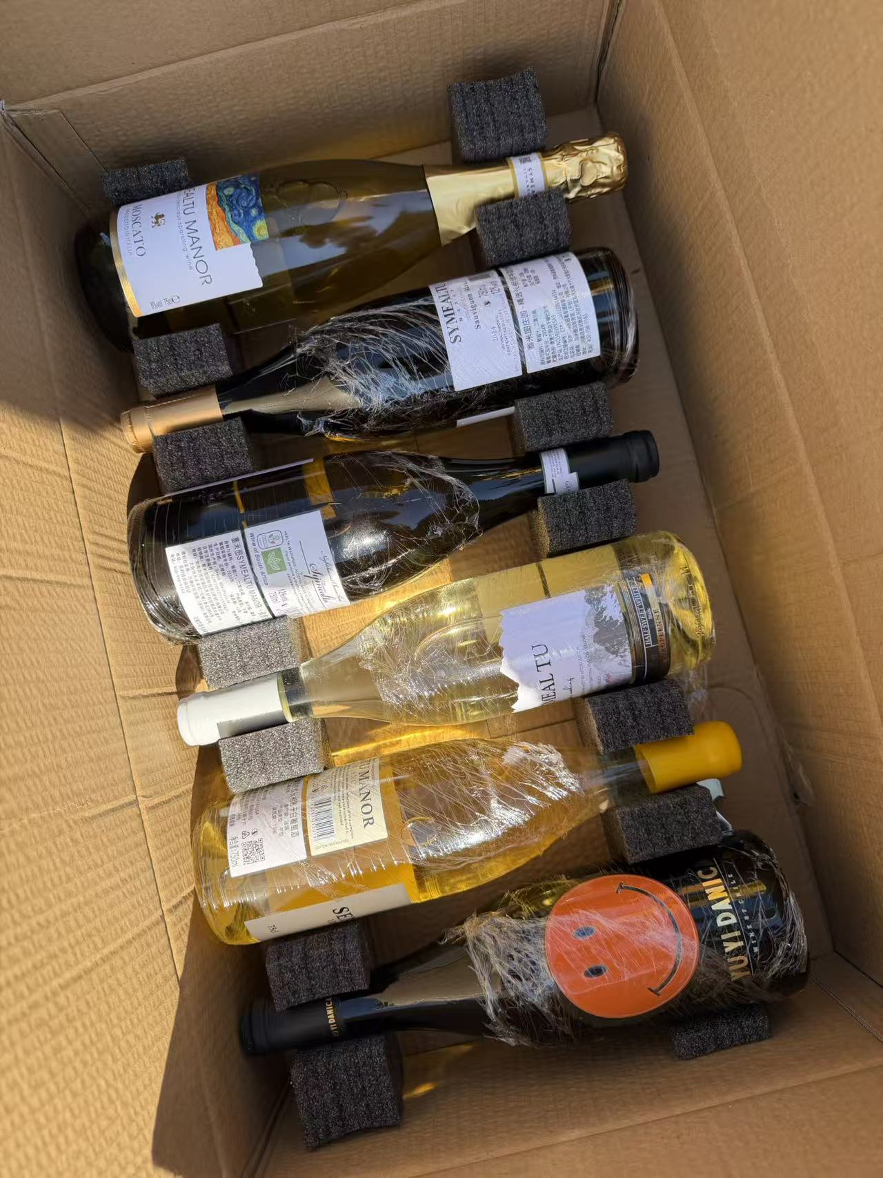 Wrapped bottles of wine in a cardboard box, ready to be chilled at the restaurant for my birthday
